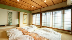 Um quarto japonês tradicional com tatames, dois tatames, um biombô shoji e teto de madeira.