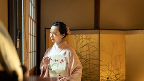 Una habitación japonesa tradicional con suelo de tatami, un separador shoji y una puerta corredera.
