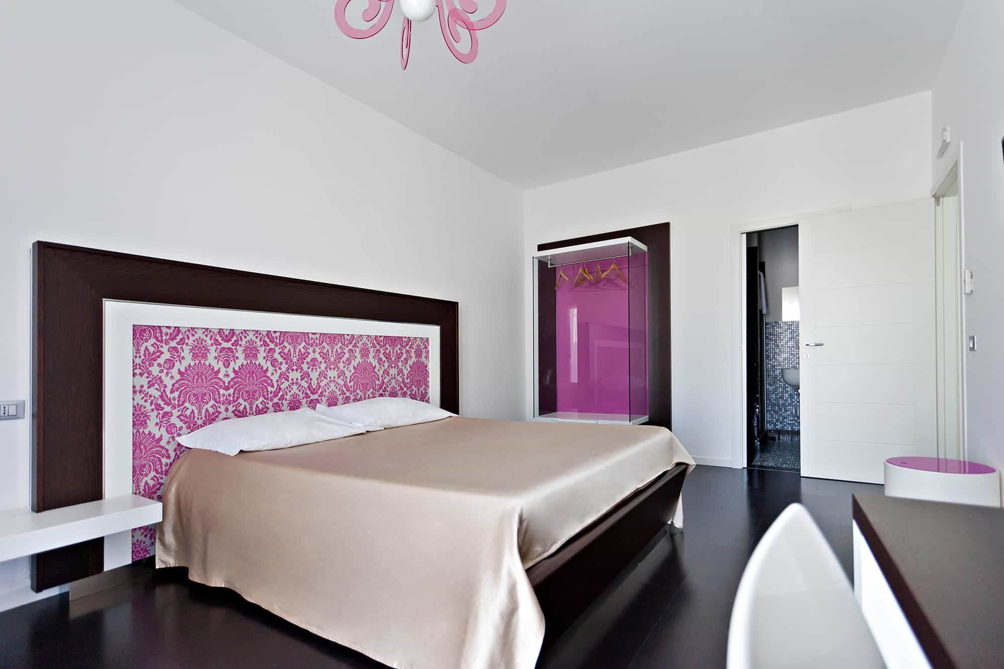 Un dormitorio moderno con una cama grande, un tocador con espejo y un vestidor.