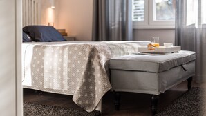 A bedroom with a bed, bedside table, and a window with curtains.
