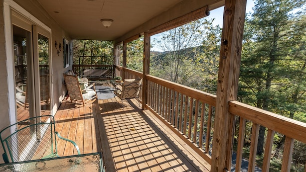A wooden deck with a railing, a glass table, and two chairs. - EnjoyThis Home in the Mountains  ,5 min walk to the River ,Boone ,West Jefferso (West Jefferson)