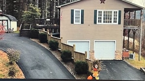 A two-story building with a star on the roof, a garage, and a wooden fence. - EnjoyThis Home in the Mountains  ,5 min walk to the River ,Boone ,West Jefferso (West Jefferson)