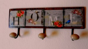 Un senyal decoratiu amb la paraula 'HOME' i motius florals.