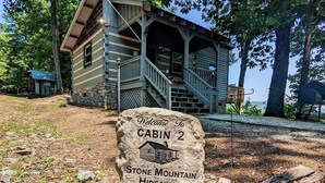 Una cabaña con un letrero de piedra que dice: 'Welcome to Cabin 2 Stone Mountain Hideaway'.