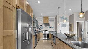 Eine moderne Küche mit Edelstahlgeräten, Holzschränken und einer Granitabdeckung.