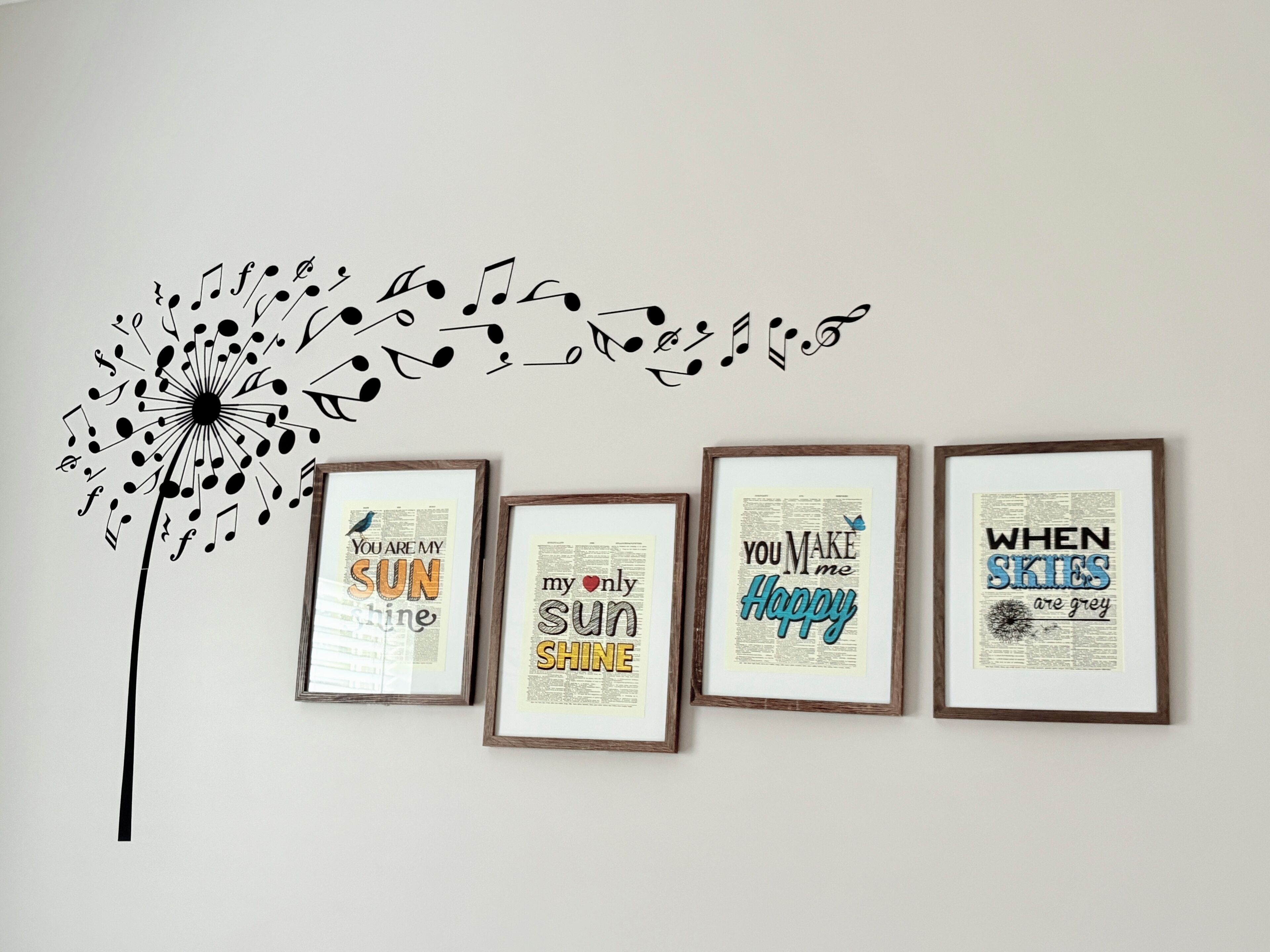 A wall with a dandelion illustration and four framed inspirational quotes.