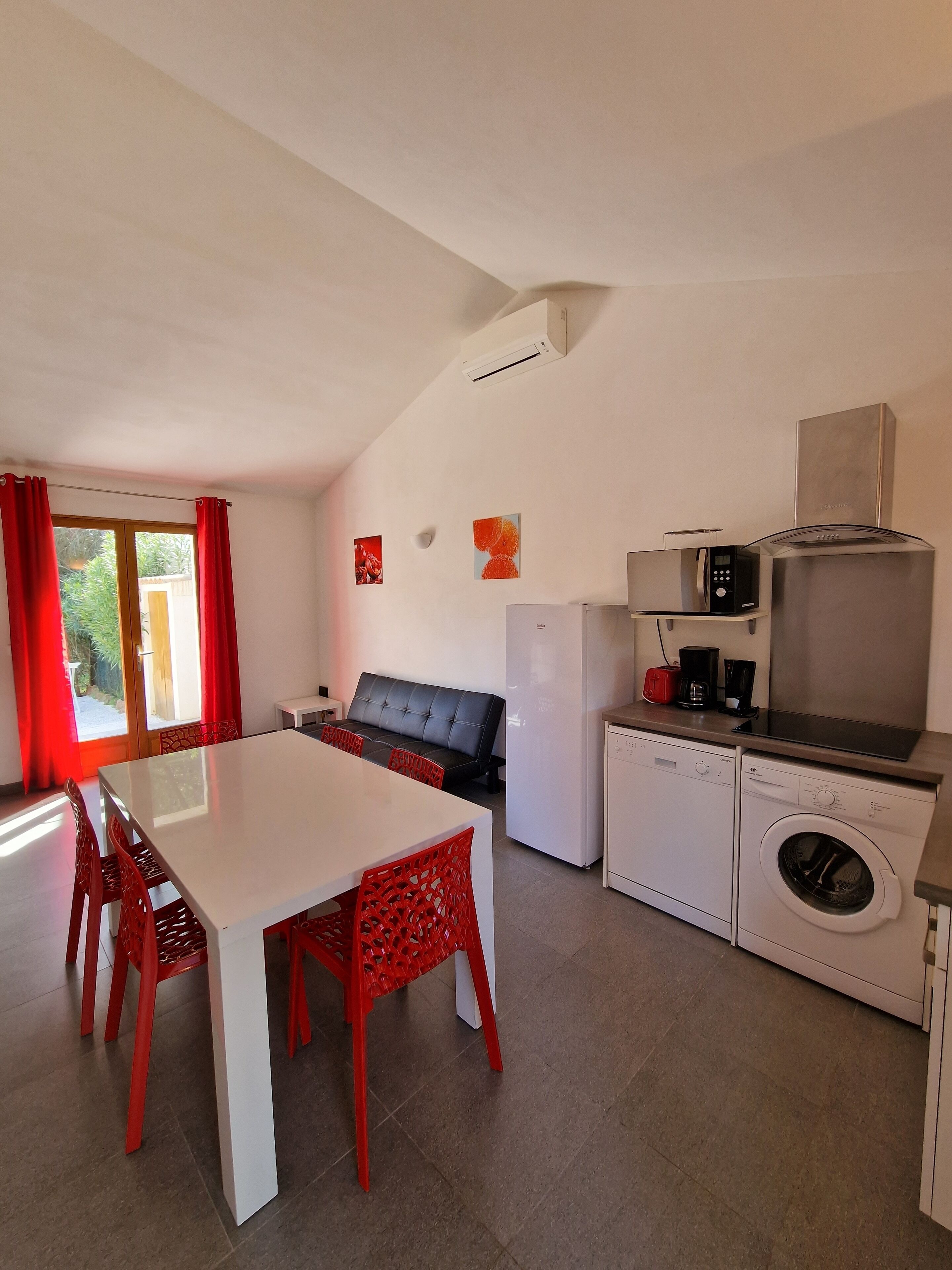 A compact kitchen with a microwave, toaster, and washing machine.