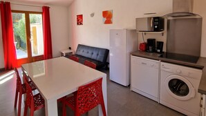 A compact kitchen with a microwave, toaster, and washing machine. - PALOMBAGGIA VILLA AIR CONDITIONED 4 PERS less than 700 meters from the beach (Porto-Vecchio)