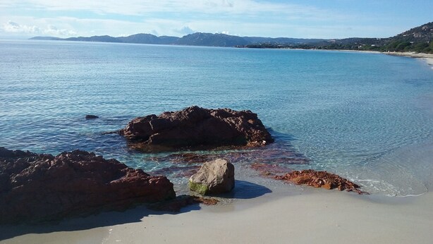 A coastal beach with clear water, rocky formations, and distant mountains. - PALOMBAGGIA VILLA AIR CONDITIONED 4 PERS less than 700 meters from the beach (Porto-Vecchio)