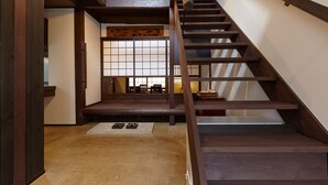 A wooden staircase with a traditional Japanese sliding door at the bottom.