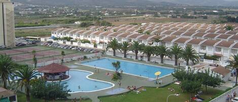 Un complexe hôtelier doté de plusieurs piscines, d’un parking et offrant une vue sur les montagnes lointaines.