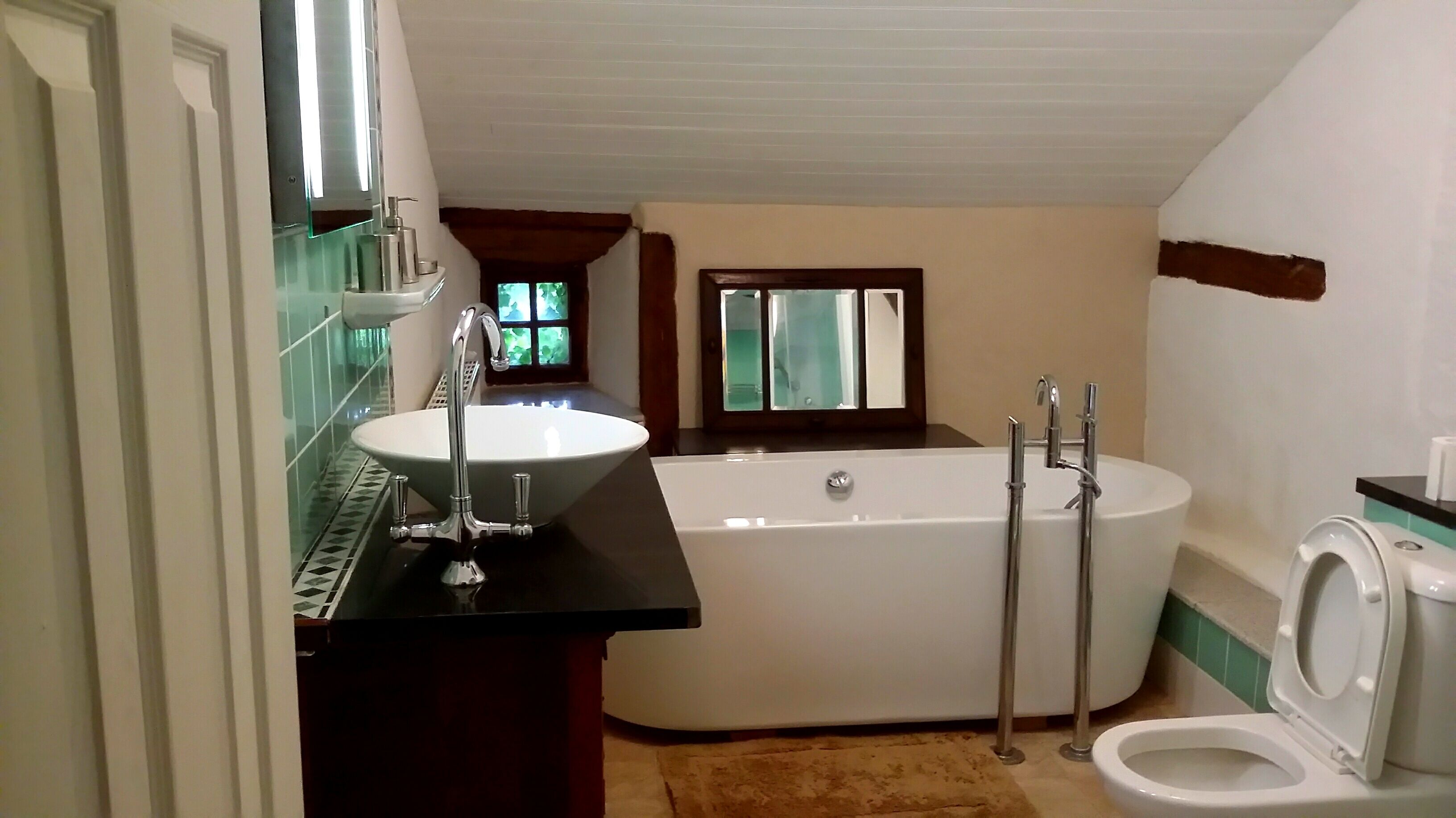 Ein Badezimmer mit freistehender Badewanne, Waschbecken und Toilette.