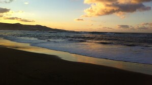 Une plage avec des vagues et un ciel dégagé.