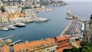 A coastal cityscape with a marina, buildings with red-tiled roofs, and a crowded promenade. - A beautiful apartment tastefully decorated ... (Nice)