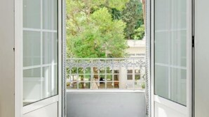 A room with a view of a balcony and trees. - A beautiful apartment tastefully decorated ... (Nice)