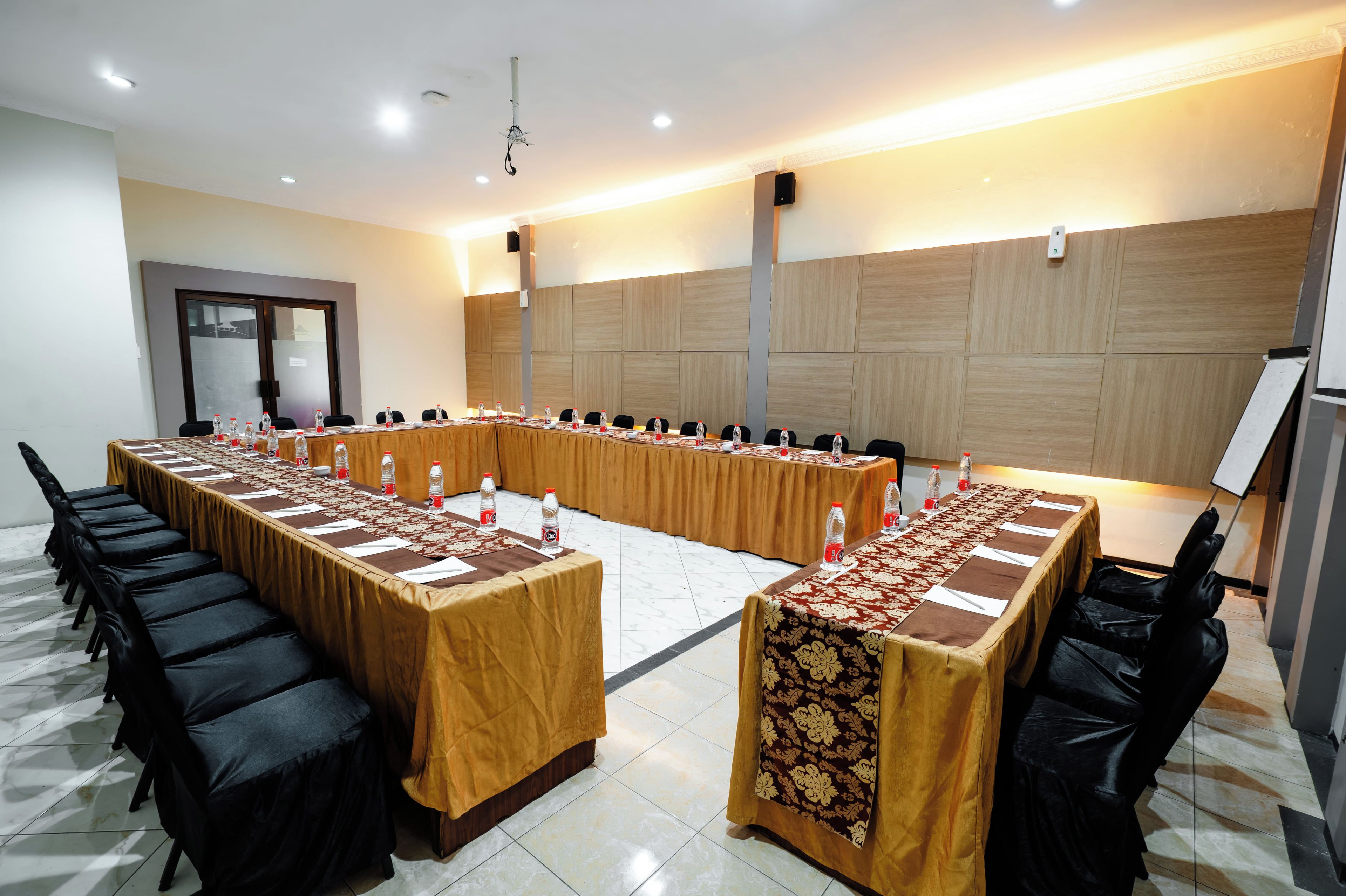 A conference room with a long table, chairs, and water bottles.