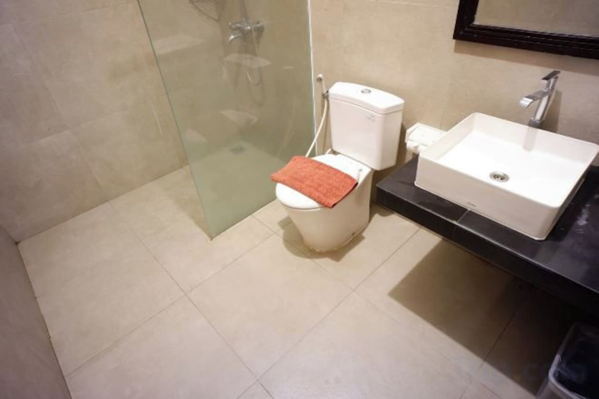A bathroom with a toilet, sink, and shower area.