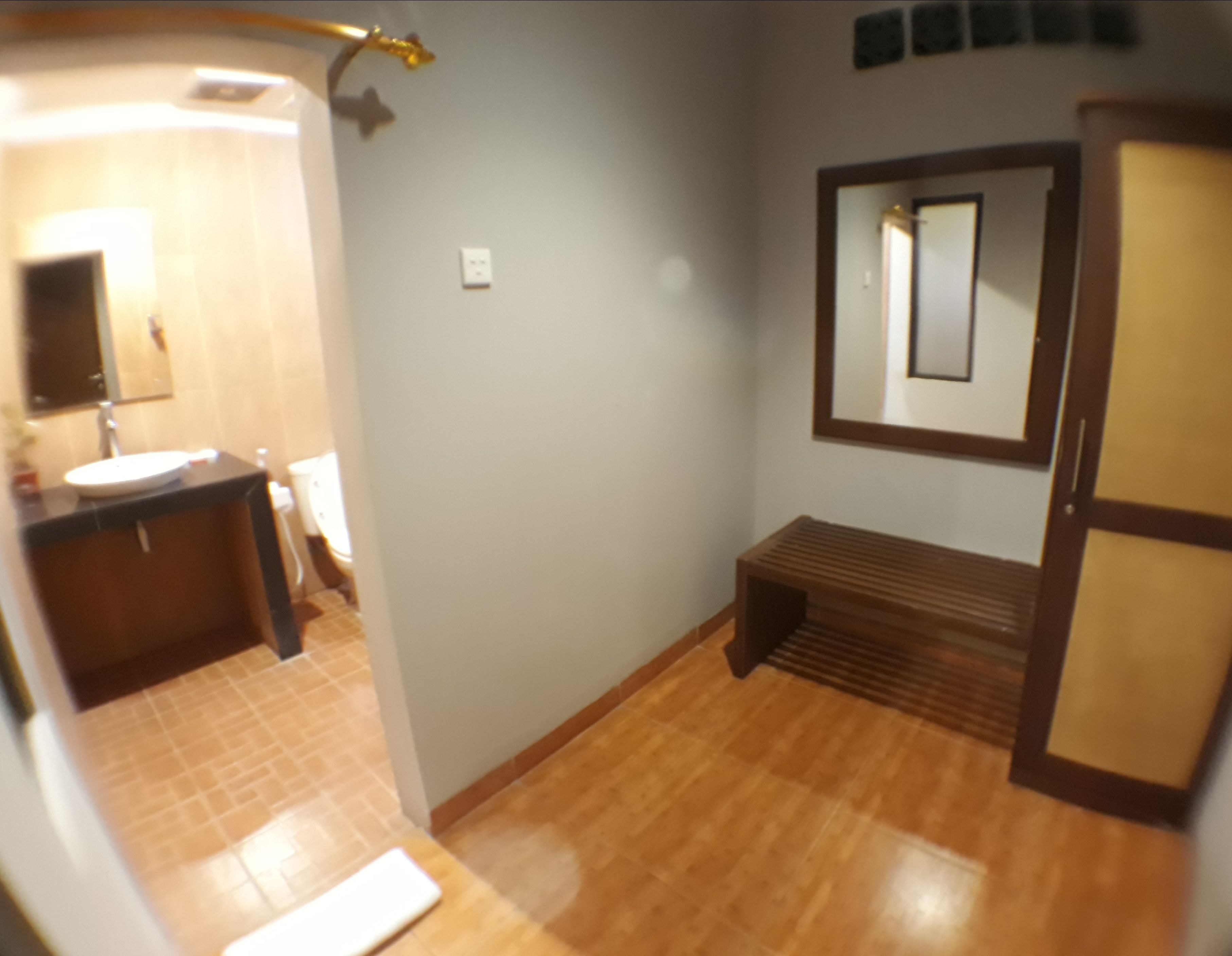 A bathroom with a sink, mirror, and bench.
