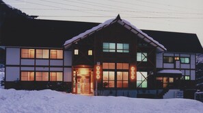 A two-story building with a snow-covered roof and large windows. - Villa Kubota (Nozawaonsen)