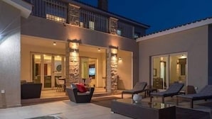 A modern house with a swimming pool, outdoor seating, and a well-lit entrance. - villa kristia (Paphos)