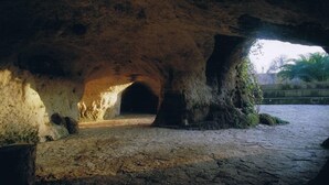 A cave entrance with a cobblestone floor and natural rock formations.