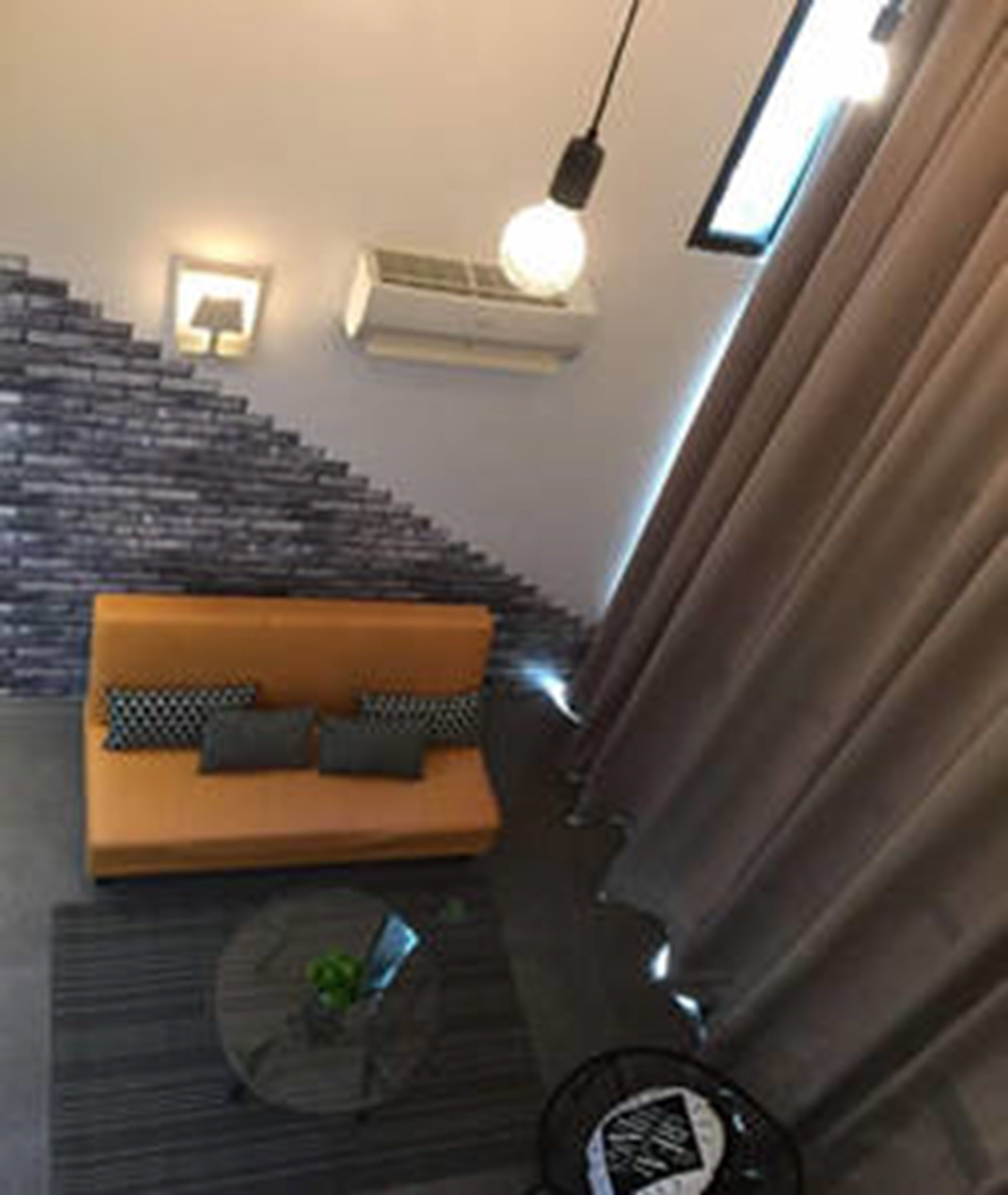 A modern living room with a staircase, a sofa, and a round coffee table.