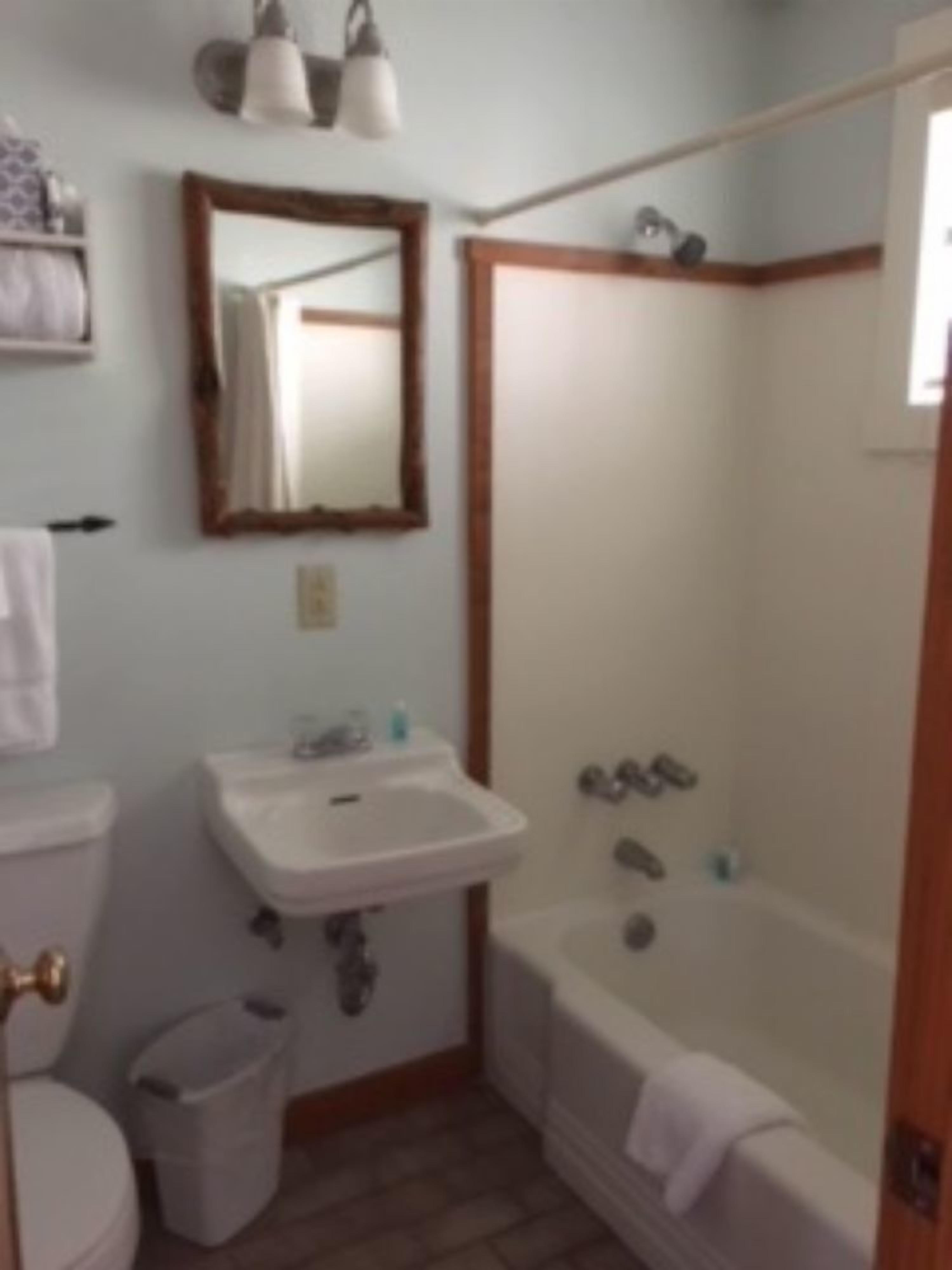 A bathroom with a toilet, sink, and bathtub.