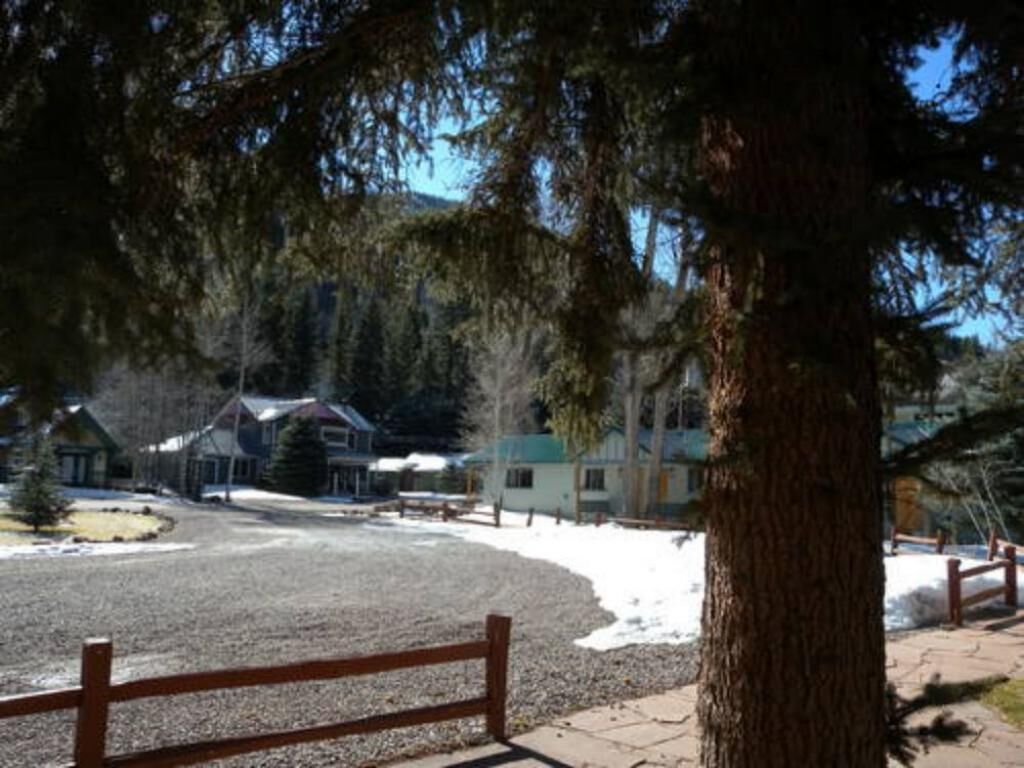 A view of a building with a gravel driveway and a wooden fence.