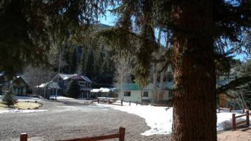 A view of a building with a gravel driveway and a wooden fence.