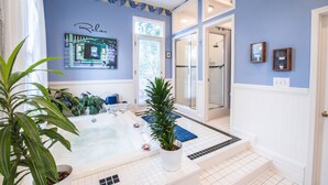 A bathroom with a bathtub, potted plants, and a towel rack. - Sugar Magnolia Bed & Breakfast (Atlanta)