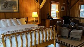 Een houten slaapkamer met een bed, twee lampen, een bureau en een stoel.