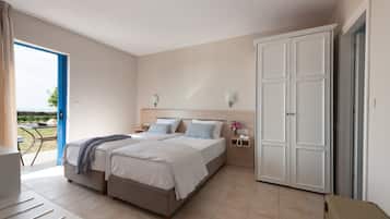 A bedroom with a bed, bedside tables, a wardrobe, and a view of the outdoors.
