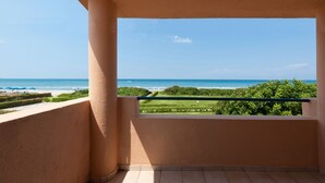 Uma varanda com vista para a praia e o oceano.