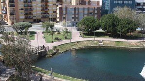 A multi-story residential building with balconies, a central courtyard with a pond, and a bridge. - Hotel Marina Peñíscola (Peniscola)