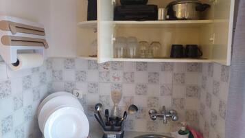 Cocina compacta con fregadero, escurreplatos y un organizador de utensilios.
