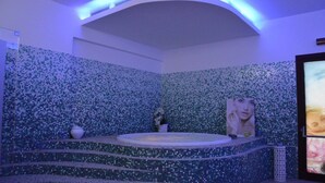 A bathroom with mosaic tile walls, a bathtub, and a poster. - Baiamalva Resort (Porto Cesareo)