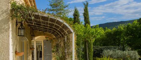 Eine Villa mit Swimmingpool, überdachter Terrasse und Garten.
