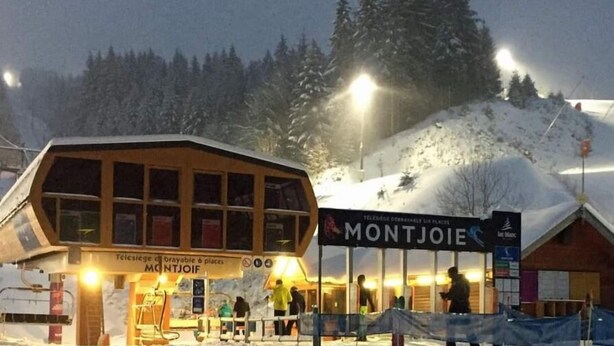 Un bâtiment appartenant à une station de ski, sur lequel on peut lire l’inscription « MONTJOIE ».