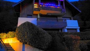 Une maison moderne à deux étages, dotée d’un balcon et d’un escalier menant à l’entrée.