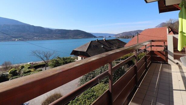 Un balcon avec vue sur un lac et des montagnes.
