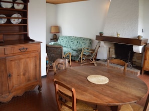 Ein Essbereich mit Holztisch, Stühlen, einer Couch und einem Kamin.