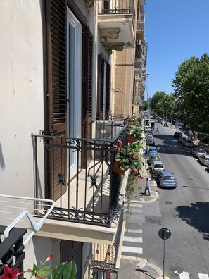 A residential building with a balcony, a street view, parked cars, and a pedestrian crossing. - Affittacamere Domus Nikolai (Bari)