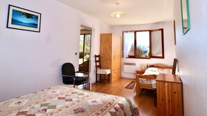Ein Schlafzimmer mit Bett, Schreibtisch, Stuhl und Kleiderschrank.