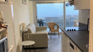 Eine moderne Küche mit Essbereich, einer Couch und Blick auf die Stadt.