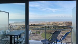 Ein Balkon mit Blick auf Strand und Meer.