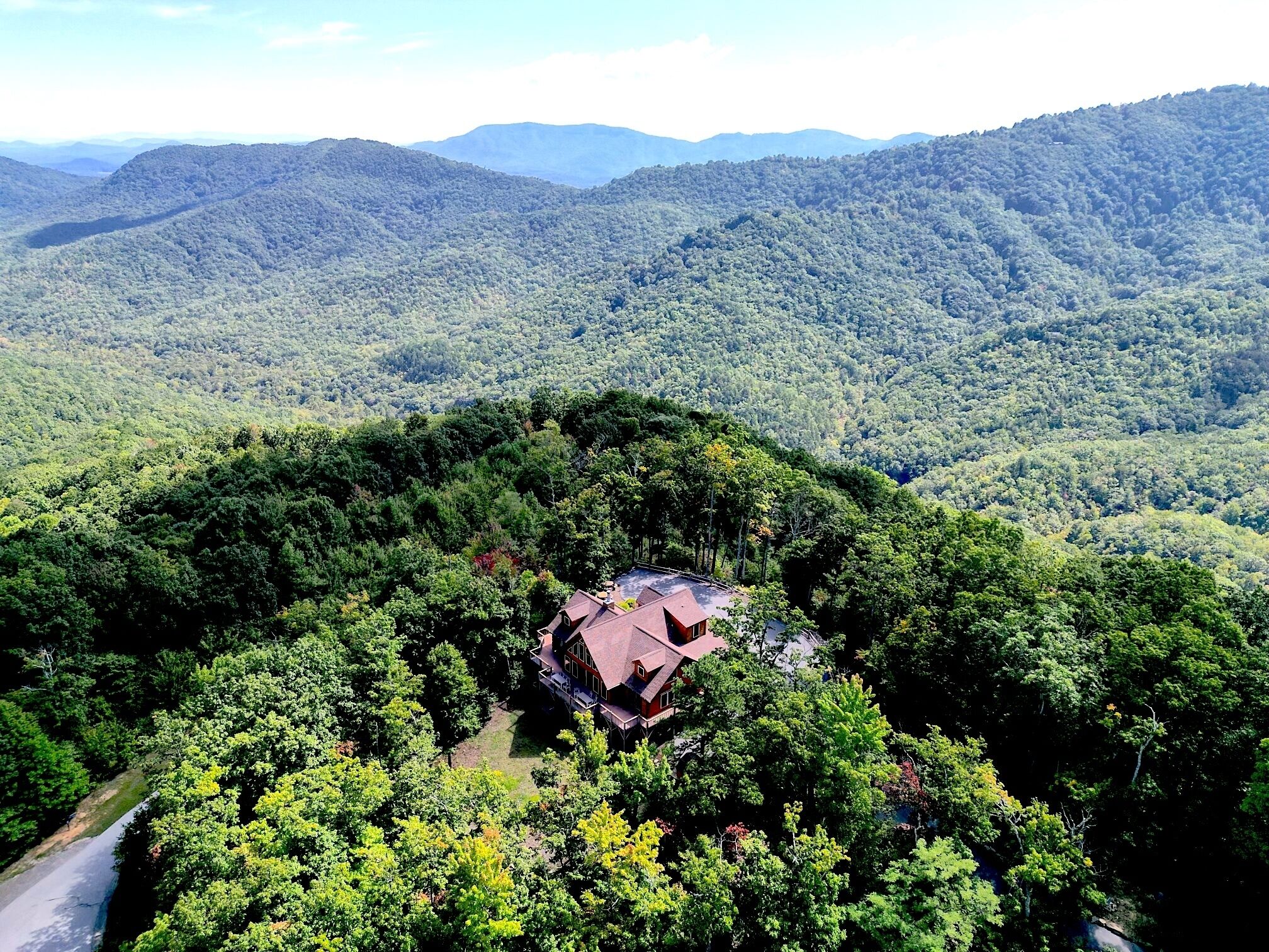 Una casa rodeada de un bosque frondoso, con vistas despejadas a las montañas circundantes.