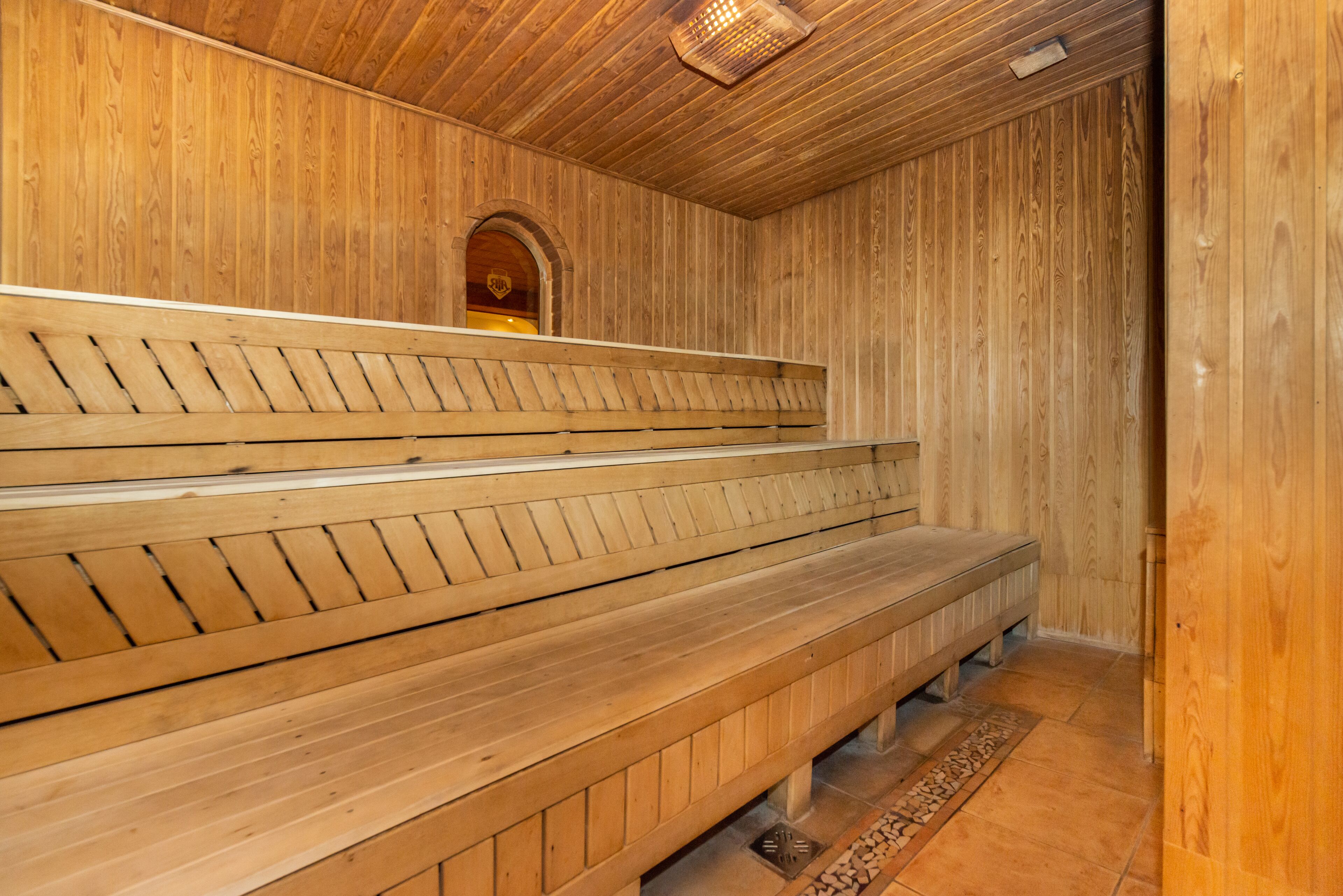 A sauna with wooden benches and a tiled floor.
