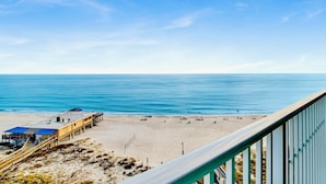 Una spiaggia con una passerella di legno che conduce a un posto di salvataggio.