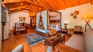A cozy room with a four-poster bed, a sofa, a small table, and a lamp. - Lemon Tree Hotel Srinagar (Srinagar)