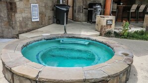 A circular stone hot tub with a stone wall surrounding it. - BLISSFUL ESCAPE - Luxurious Condo in Perfect Location near Dollywood Sleeping 7 (Pigeon Forge)